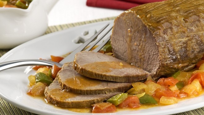 Imagem de carne de panela com molho em um prato branco com um garfo ao lado