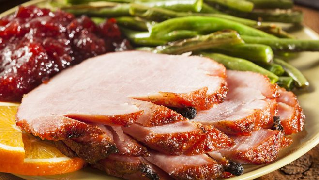 Tender com molho de framboesa ao lado uma rodela de laranja