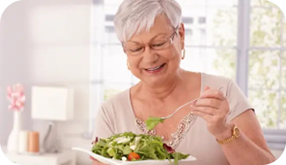 Mulher sorrindo comendo uma salada