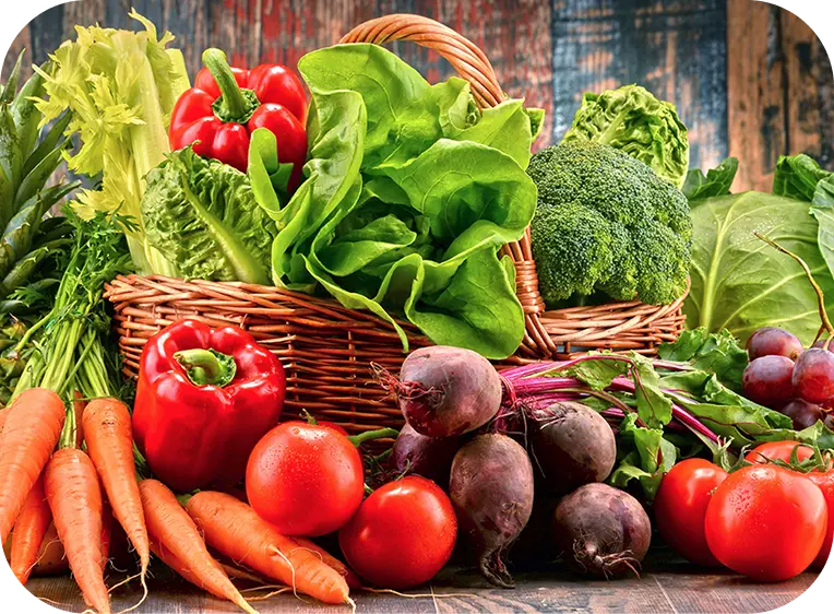 Cesta com legumas e vegetais dentro e em volta dela