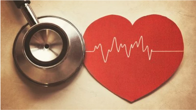 Estetoscópio ao lado de um coração de papel vermelho