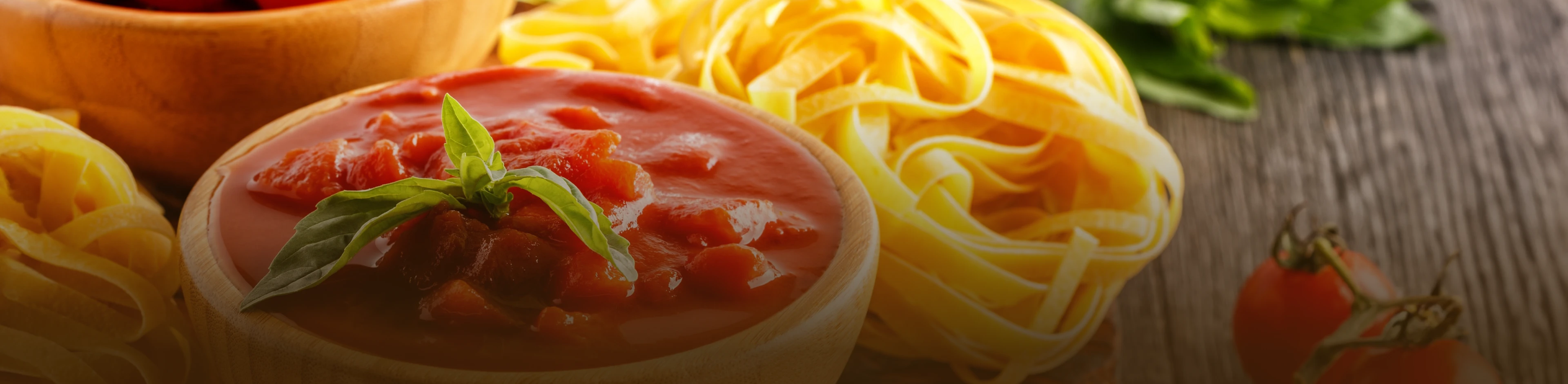 Tábua de madeira com ingredientes para preparar uma macarronada